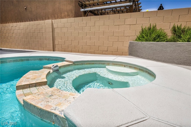 view of pool featuring fence and a pool with connected hot tub