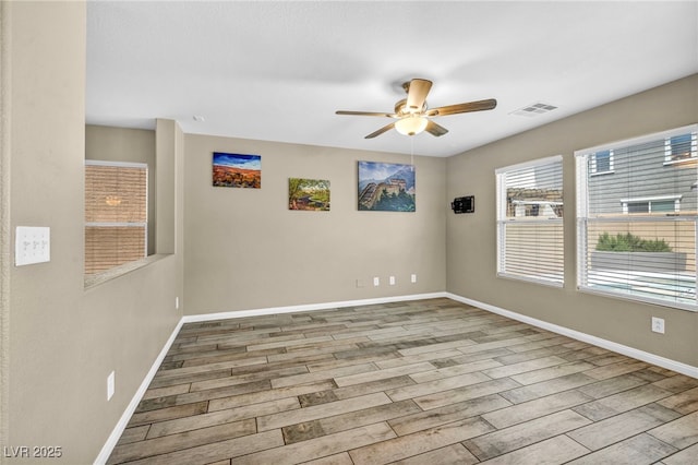 unfurnished room with ceiling fan, wood finished floors, and baseboards