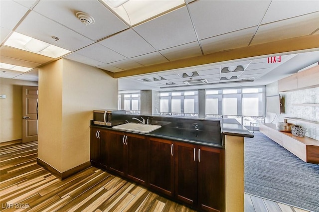 150 Las Vegas Blvd Unit 2016, North Las Vegas, NV 89101 - kitchen featuring a sink, a peninsula, dark countertops, wood finished floors, and stainless steel microwave