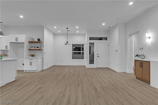 10801 Clarion Ln, Las Vegas, NV 89134 - unfurnished living room featuring light wood-type flooring, recessed lighting, baseboards, and a chandelier