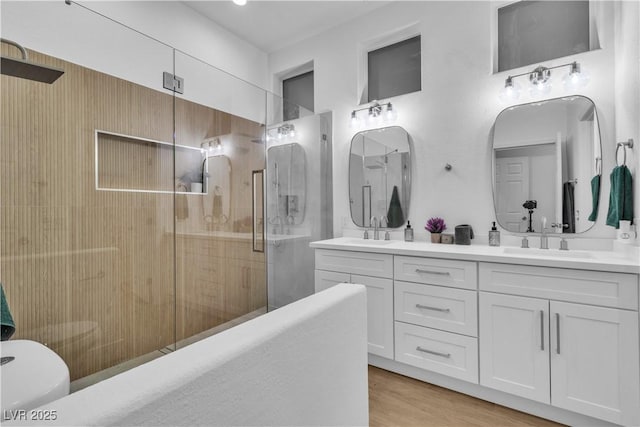 10801 Clarion Ln, Las Vegas, NV 89134 - bathroom with a stall shower, double vanity, and wood finished floors