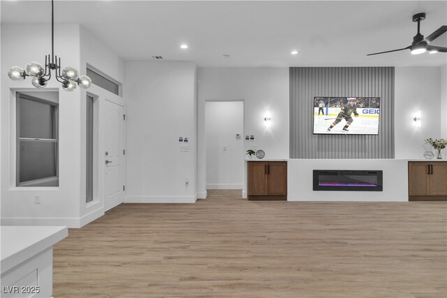 10801 Clarion Ln, Las Vegas, NV 89134 - unfurnished living room with light wood-type flooring, recessed lighting, ceiling fan, a glass covered fireplace, and baseboards