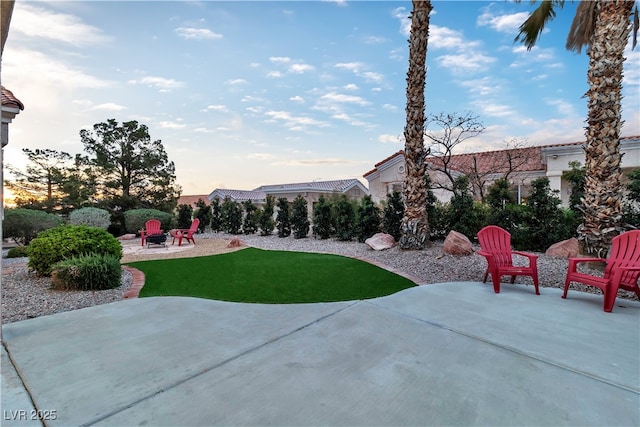10801 Clarion Ln, Las Vegas, NV 89134 - yard at dusk featuring a patio, an outdoor fire pit, and a lawn