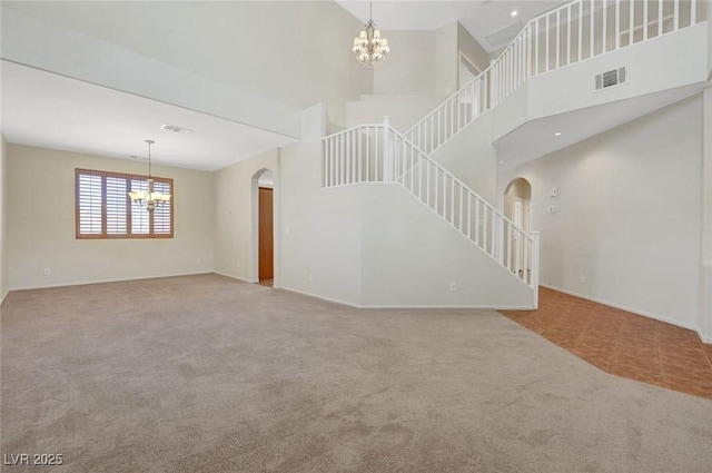 11444 Steponia Bay St, Las Vegas, NV 89141 - unfurnished living room with a chandelier, arched walkways, carpet flooring, stairs, and a high ceiling