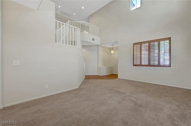 11444 Steponia Bay St, Las Vegas, NV 89141 - unfurnished living room featuring a towering ceiling, plenty of natural light, carpet flooring, and baseboards