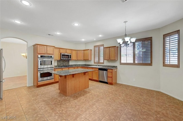 11444 Steponia Bay St, Las Vegas, NV 89141 - kitchen featuring appliances with stainless steel finishes, a chandelier, a kitchen island, recessed lighting, and light stone counters