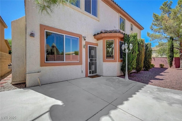 11444 Steponia Bay St, Las Vegas, NV 89141 - doorway to property with stucco siding, fence, a patio area, and a tiled roof