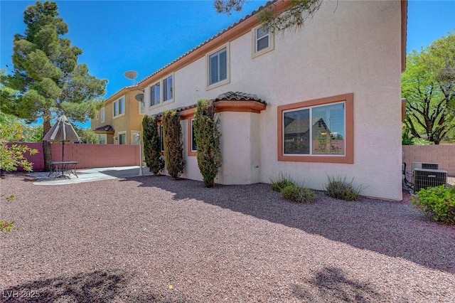 11444 Steponia Bay St, Las Vegas, NV 89141 - rear view of property featuring central AC unit, fence, a patio, stucco siding, and a tile roof