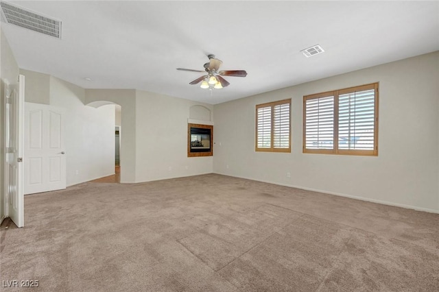 11444 Steponia Bay St, Las Vegas, NV 89141 - empty room featuring a ceiling fan, arched walkways, carpet flooring, a tile fireplace, and baseboards