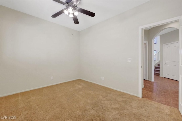 11444 Steponia Bay St, Las Vegas, NV 89141 - carpeted empty room featuring arched walkways, baseboards, a ceiling fan, and stairway