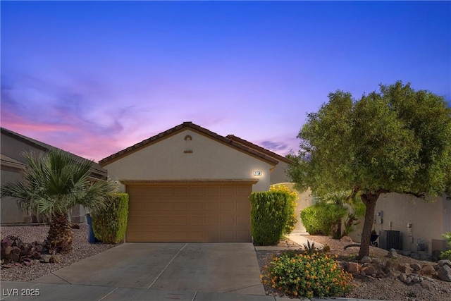 view of front of house with stucco siding, a garage, and concrete driveway