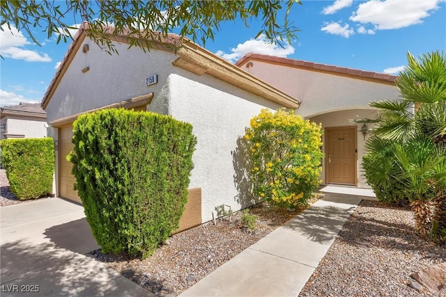 view of side of property featuring stucco siding and a garage