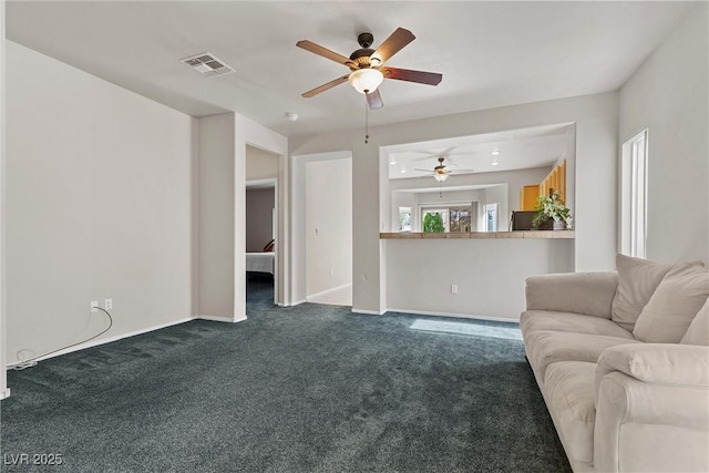 living area with a ceiling fan, dark colored carpet, and baseboards