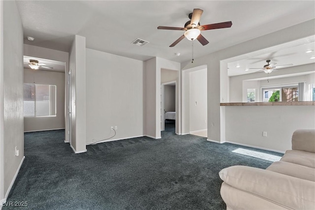 living area with ceiling fan, dark carpet, and baseboards