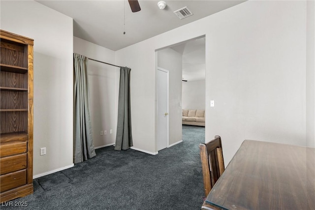 home office with dark colored carpet, a ceiling fan, and baseboards