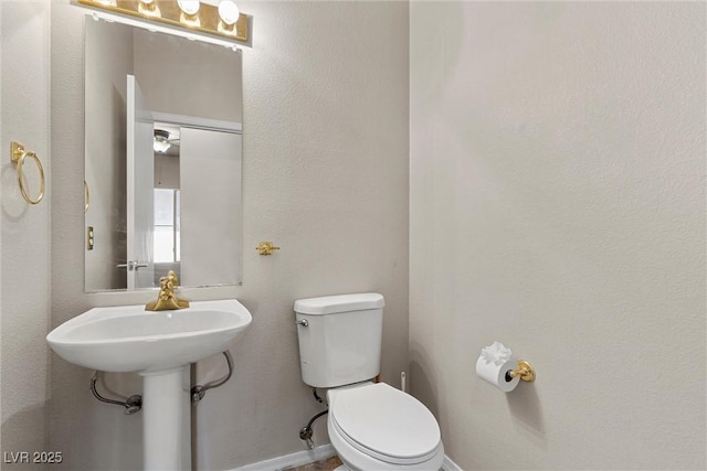 bathroom featuring toilet and baseboards