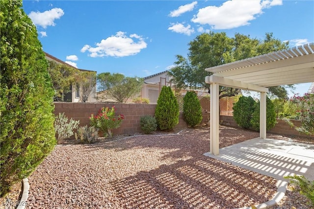 fenced backyard with a pergola and a patio area