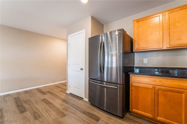 3855 Park Field Dr, Las Vegas, NV 89120 - kitchen with freestanding refrigerator, wood finished floors, dark stone counters, and baseboards