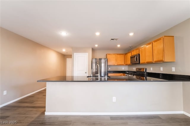 3855 Park Field Dr, Las Vegas, NV 89120 - kitchen featuring stainless steel appliances, baseboards, a peninsula, dark countertops, and recessed lighting