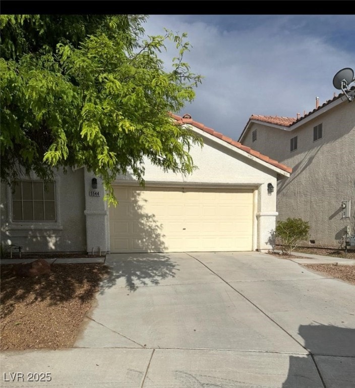 5544 Cloudy Glen St, North Las Vegas, NV 89031 - view of front of home with stucco siding, driveway, a garage, and a tiled roof