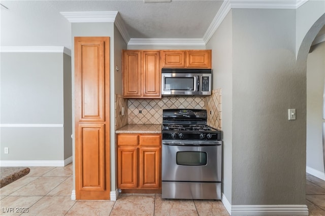2700 N Rainbow Blvd Unit 1080, Las Vegas, NV 89108 - kitchen featuring stainless steel appliances, decorative backsplash, crown molding, light countertops, and arched walkways