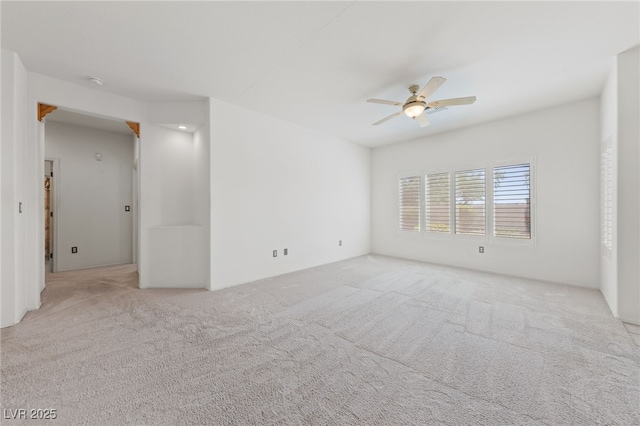 empty room with carpet, a ceiling fan, and a smoke detector