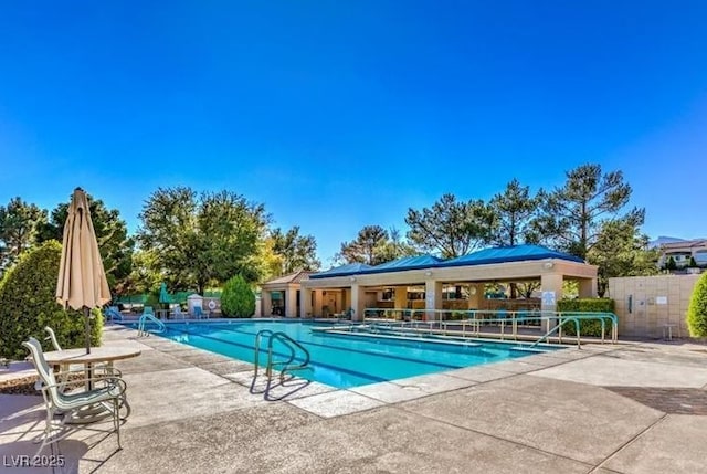 community pool with a patio and fence