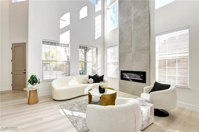 5737 Heather Breeze Ct, Las Vegas, NV 89141 - living room with a high ceiling, wood finished floors, baseboards, and a large fireplace