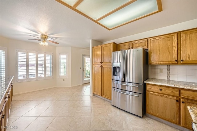 2520 Palmridge Dr, Las Vegas, NV 89134 - kitchen with stainless steel fridge, ceiling fan, decorative backsplash, and brown cabinets