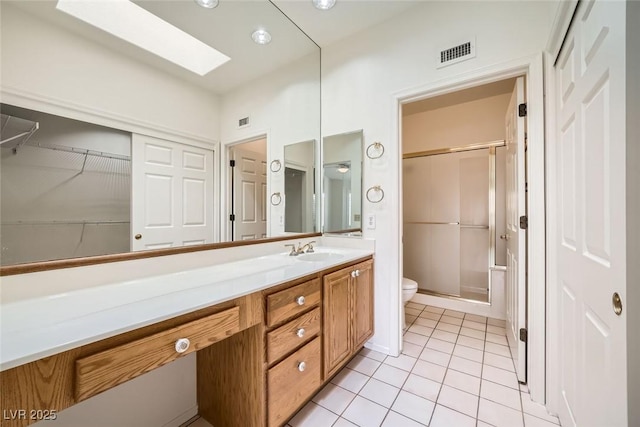 2520 Palmridge Dr, Las Vegas, NV 89134 - bathroom with toilet, a stall shower, vanity, tile patterned floors, and a skylight
