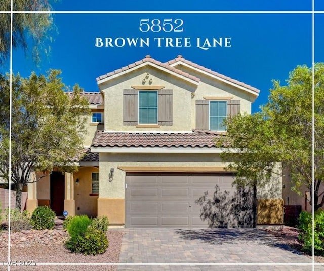 view of front of home with a garage, a tile roof, stucco siding, and decorative driveway