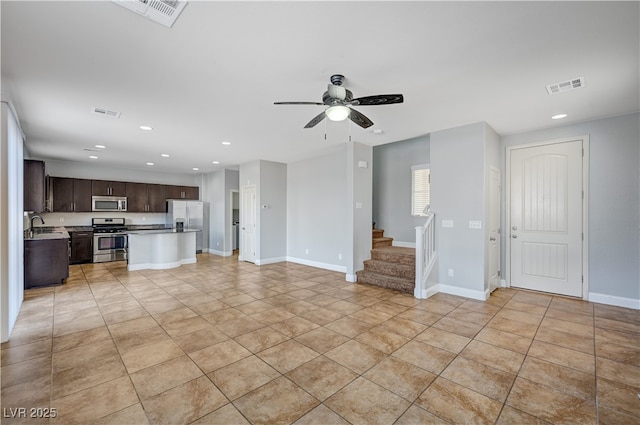 unfurnished living room featuring ceiling fan, recessed lighting, a sink, stairway, and light tile patterned floors