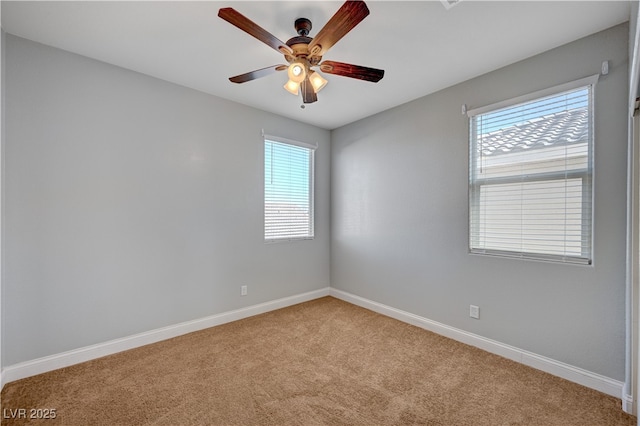 spare room with light carpet, baseboards, and a ceiling fan