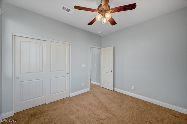 unfurnished bedroom with carpet flooring, baseboards, a closet, and a ceiling fan