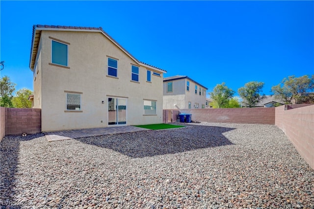 back of property with a fenced backyard, a patio area, and stucco siding