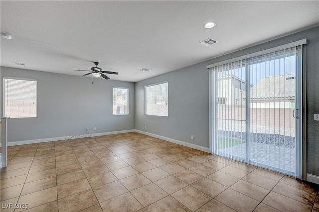 tiled empty room with a ceiling fan and baseboards