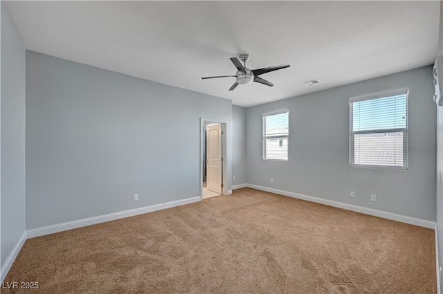 spare room featuring carpet, baseboards, and a ceiling fan