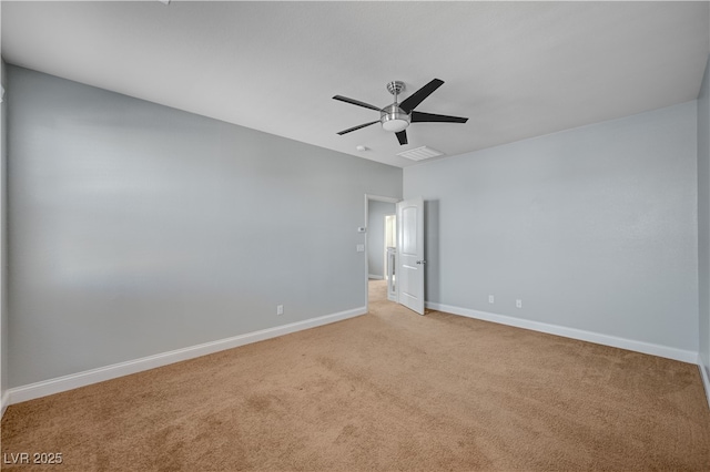 empty room with light colored carpet, baseboards, and a ceiling fan