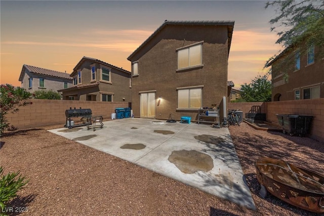 back of house with a fire pit, a patio area, and a fenced backyard