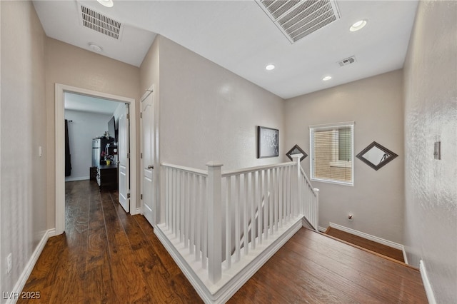 hall with an upstairs landing, wood finished floors, baseboards, and recessed lighting