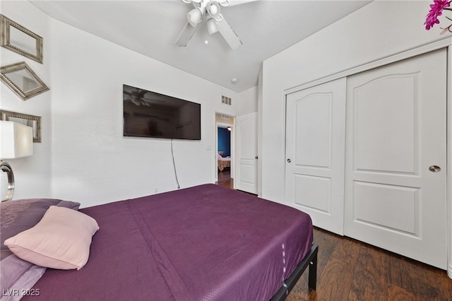 bedroom with dark wood-type flooring, a closet, and ceiling fan