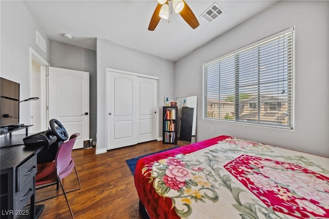 bedroom featuring dark wood-type flooring, a closet, an office area, and ceiling fan