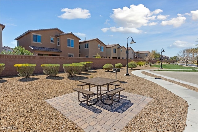 view of community featuring a residential view, fence, a patio area, and outdoor dining area