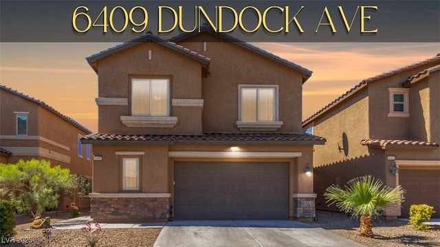 view of front of house featuring stone siding, stucco siding, an attached garage, a tiled roof, and concrete driveway