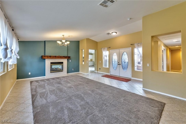 tiled foyer entrance featuring a chandelier and baseboards