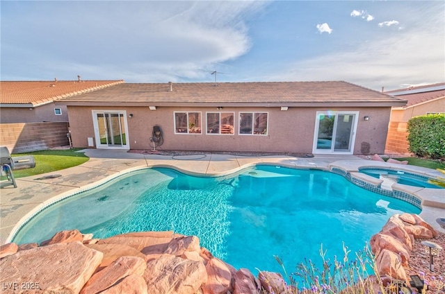 view of pool with a fenced backyard, a pool with connected hot tub, and a patio