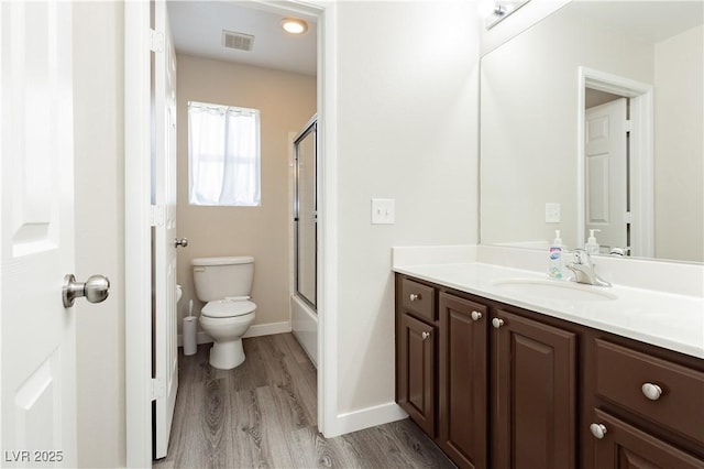 8717 Early Horizon Dr, Las Vegas, NV 89178 - full bathroom with toilet, vanity, wood finished floors, baseboards, and shower / bath combination with glass door