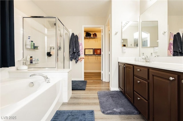8717 Early Horizon Dr, Las Vegas, NV 89178 - full bath with a stall shower, wood finished floors, a garden tub, vanity, and a walk in closet