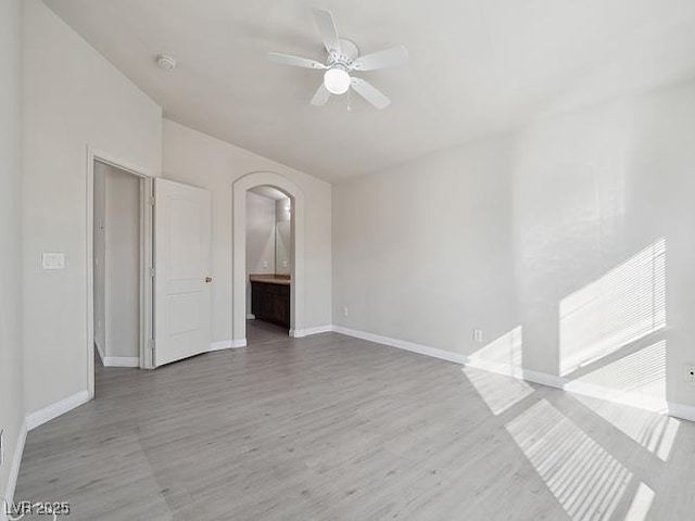 4830 Double Down Dr Unit 102, Las Vegas, NV 89122 - unfurnished room with arched walkways, a ceiling fan, baseboards, wood finished floors, and a smoke detector