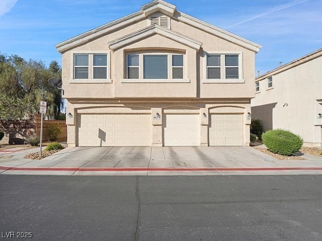 4830 Double Down Dr Unit 102, Las Vegas, NV 89122 - view of front of house featuring an attached garage, concrete driveway, and stucco siding